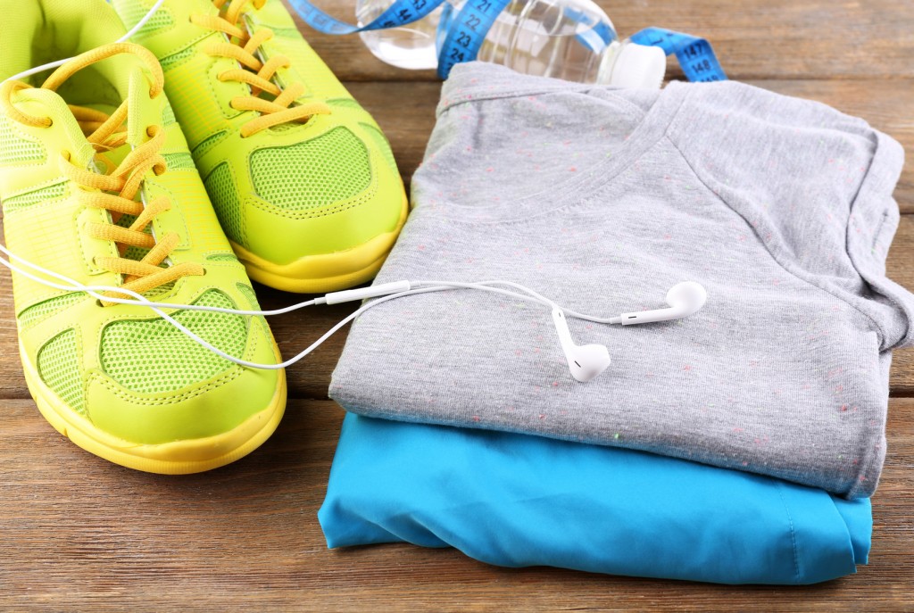 Sport shoes and clothes on wooden background